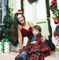 Happy smiling family on Christmas at house with gifts, young mother and little son in Santas red hat, lifestyle holiday