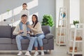 Happy smiling family. Daughter sits on fathers shoulders with mother sitting on the sofa Royalty Free Stock Photo