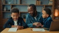 Happy smiling family e-learning home education African American father man private teacher with two boys kids children Royalty Free Stock Photo