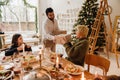 Happy family exchanging gifts while having dinner at table near Christmas tree Royalty Free Stock Photo