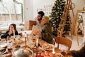 Happy family exchanging gifts while having dinner at table near Christmas tree Royalty Free Stock Photo