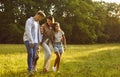 Happy family of four with kids walking in summer park enjoying beautiful nature. Royalty Free Stock Photo