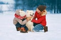 Happy smiling family having fun together in winter day, mother and child walking with white Samoyed dog Royalty Free Stock Photo