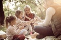 Smiling family having picnic together in park and talking. Royalty Free Stock Photo