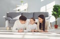 Happy smiling family hugging while lying on the floor in the room at home. C Royalty Free Stock Photo