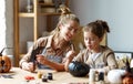 Happy smiling family mother and daughter making Halloween home decorations together