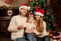 Happy smiling family near the Christmas tree celebrate New Year.