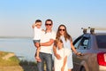 Happy smiling family with two kids by the car with sea background. Portrait of a smiling family with two children at beach by Royalty Free Stock Photo