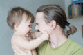 Happy smiling father and baby daughter portrait. Handsome bearded young man holding infant little girl Royalty Free Stock Photo