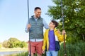 Happy smiling father and son fishing on river Royalty Free Stock Photo