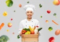 happy smiling female chef with food in wooden box Royalty Free Stock Photo