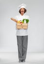 Happy smiling female chef with food in wooden box Royalty Free Stock Photo