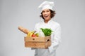 Happy smiling female chef with food in wooden box Royalty Free Stock Photo