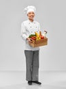 happy smiling female chef with food in wooden box Royalty Free Stock Photo