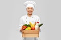 happy smiling female chef with food in wooden box Royalty Free Stock Photo