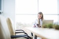 Happy smiling female customer support phone operator at workplace make notice in notebook. Royalty Free Stock Photo