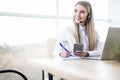 Happy smiling female customer support phone operator at workplace Royalty Free Stock Photo