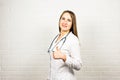 Happy smiling female doctor showing thumbs up hand sign gesture, at office, with blank copyspace area for slogan or Royalty Free Stock Photo