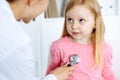 Happy smiling female kid-patient at usual medical inspection. Doctor and young girl in the clinic. Medicine, healthcare Royalty Free Stock Photo