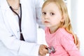 Happy smiling female kid-patient at usual medical inspection. Doctor and young girl in the clinic. Medicine, healthcare Royalty Free Stock Photo