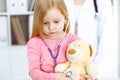 Happy smiling female kid-patient at usual medical inspection. Doctor and young girl in the clinic. Medicine, healthcare Royalty Free Stock Photo