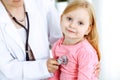 Happy smiling female kid-patient at usual medical inspection. Doctor and young girl in the clinic. Medicine, healthcare Royalty Free Stock Photo