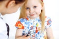 Happy smiling female kid-patient at usual medical inspection. Doctor and young girl in the clinic. Medicine, healthcare Royalty Free Stock Photo