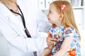 Happy smiling female kid-patient at usual medical inspection. Doctor and young girl in the clinic. Medicine, healthcare Royalty Free Stock Photo