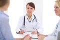 Happy smiling female patient with two cheerful doctors in the background. Royalty Free Stock Photo