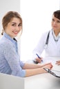 Happy smiling female patient with two cheerful doctors in the background. Royalty Free Stock Photo