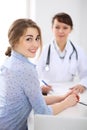 Happy smiling female patient with two cheerful doctors in the background. Royalty Free Stock Photo