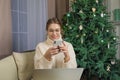 Happy smiling female reading on mobile phone text message with Christmas greetings Royalty Free Stock Photo