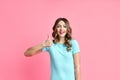 Happy smiling female showing thumbs up on pink background Royalty Free Stock Photo