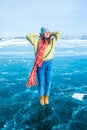 Happy smiling female traveler enjoying good day while standing on frozen Baikal lake