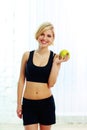 Happy smiling fit woman holding green apple Royalty Free Stock Photo