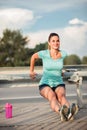 Happy fit young woman doing dips on a road-side guard rail