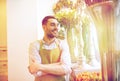 Happy smiling florist man standing at flower shop