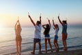 Happy smiling friends running at the beach with sparkling candles Royalty Free Stock Photo