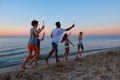 Happy smiling friends running at the beach with sparkling candles Royalty Free Stock Photo