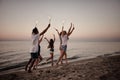 Happy smiling friends running at the beach with sparkling candles Royalty Free Stock Photo