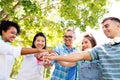 Happy smiling friends stacking hands in park Royalty Free Stock Photo