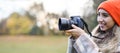 Happy smiling girl with camera. Photographer, hobby. Young woman takes photo outdoors. Banner Royalty Free Stock Photo