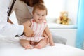 Happy smiling girl-child at usual medical inspection. Doctor and female toddler patient in the clinic. Medicine concept Royalty Free Stock Photo