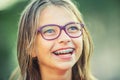 Happy smiling girl with dental braces and glasses. Young cute caucasian blond girl wearing teeth braces and glasses Royalty Free Stock Photo