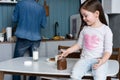 Happy smiling girl eating sandwich for breakfast and looking at the camera in the kitchen Royalty Free Stock Photo