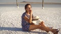 Happy smiling girl enjoying the sunset, eating watermelon, sit on salt, pillars