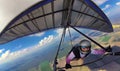 Happy smiling girl hang glider pilot shows thumb up high in the sky