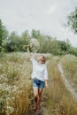 Happy smiling girl holding bouquet of field flowers having a walk in the countryside Royalty Free Stock Photo