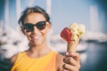 Happy, smiling girl holding ice cream cone with colorful ice cream balls. Sunny sea coastline at the background Royalty Free Stock Photo