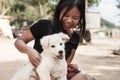 Happy smiling girl holding a white dog puppy in her hand outdoor Royalty Free Stock Photo